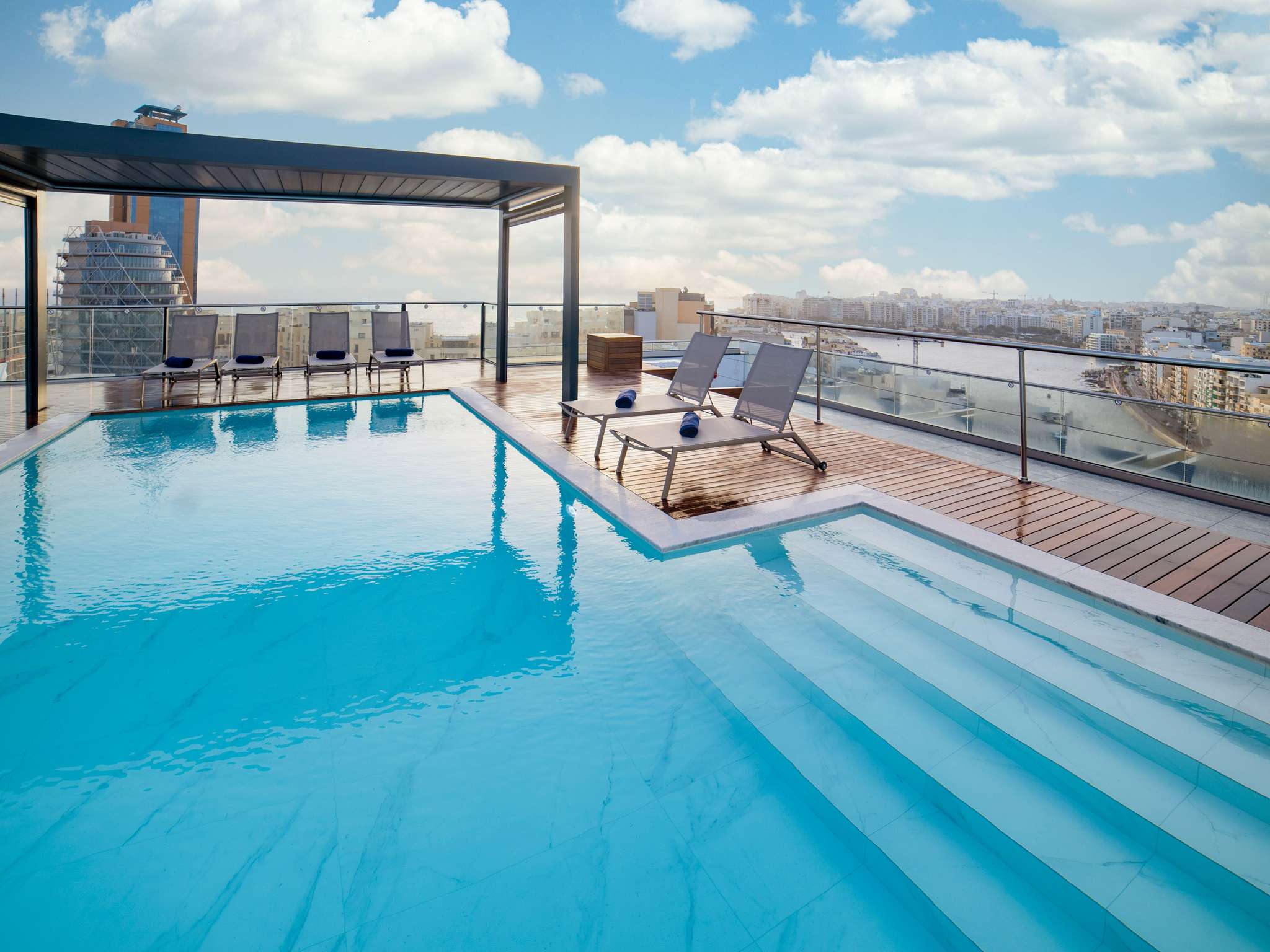 Luxury hotel pool terrace at dusk Malta with glowing lights — search: luxury hotel pool terrace night dusk Malta 5 star