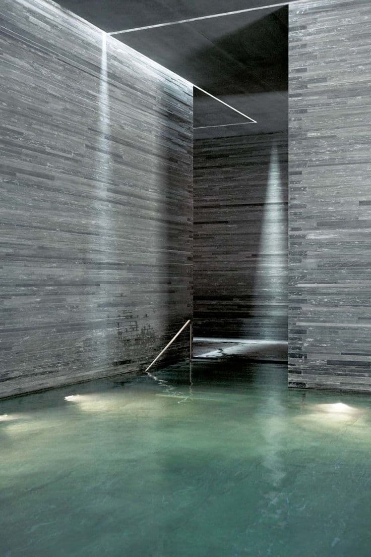 Indoor thermal pool spa hotel with atmospheric lighting stone walls — search: luxury hotel indoor thermal pool atmospheric lighting stone walls