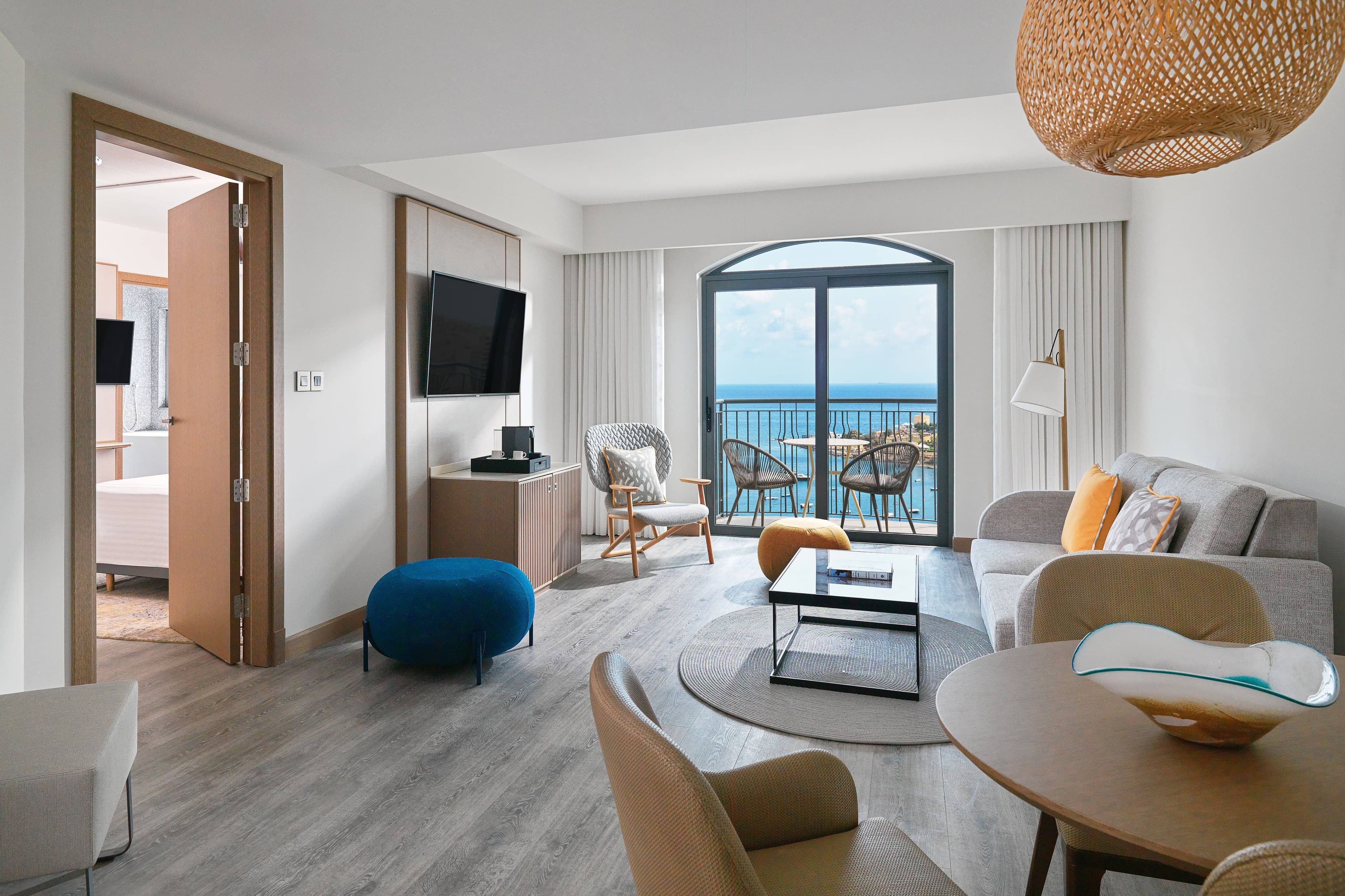 Grand sea-view suite with floor-to-ceiling windows overlooking Malta harbour — search: luxury grand suite sea view hotel room Malta