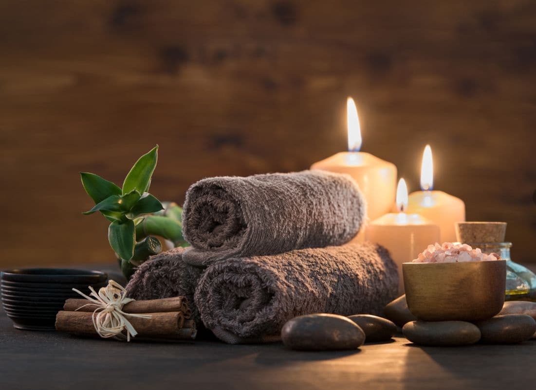 Serene spa therapist preparing treatment with essential oils candles — search: spa therapist preparing treatment essential oils candles serenity